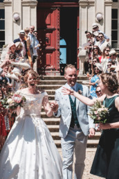 Bride and groom at French Chateau wedding laughing as confetti thrown