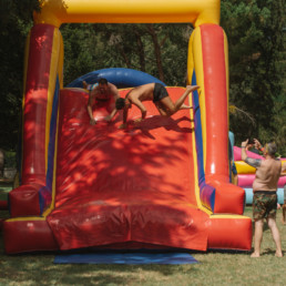 Two_men_falling_down_inflatable_slide_at_wedding_pool_party